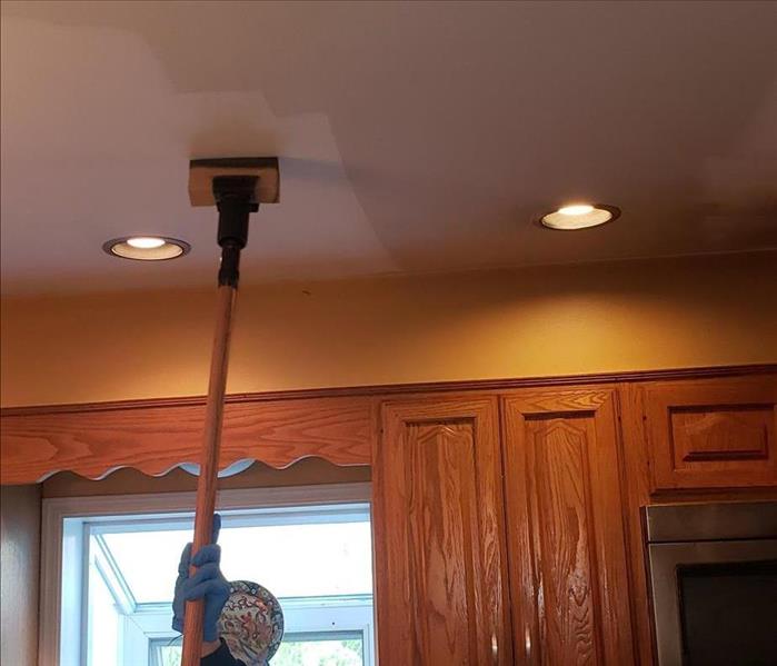 tech cleaning soot from ceiling with sponge unit